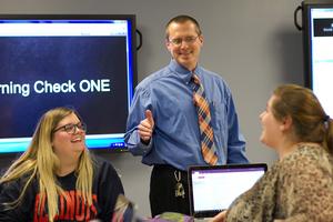 David Rosch in a classroom with two students.