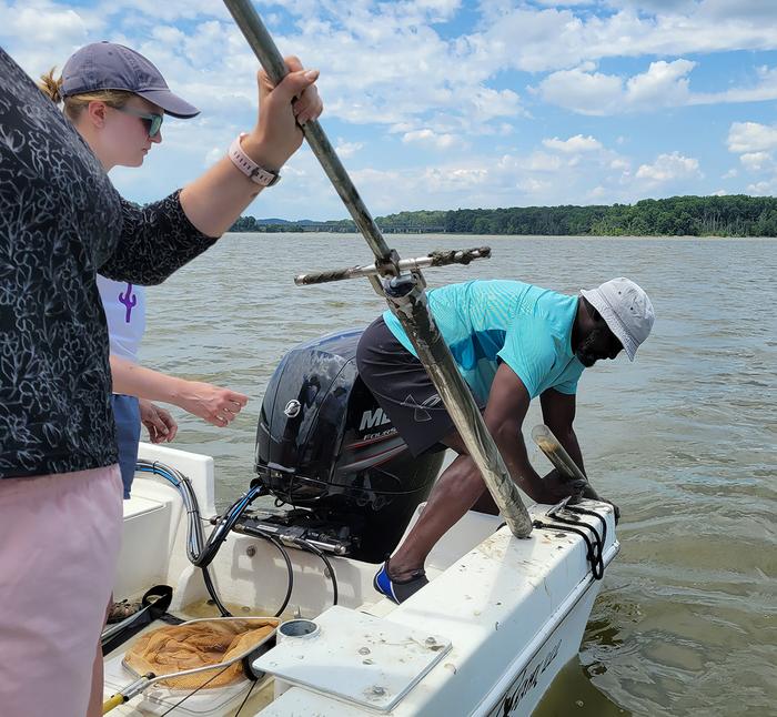 Researchers collect sediment for testing.