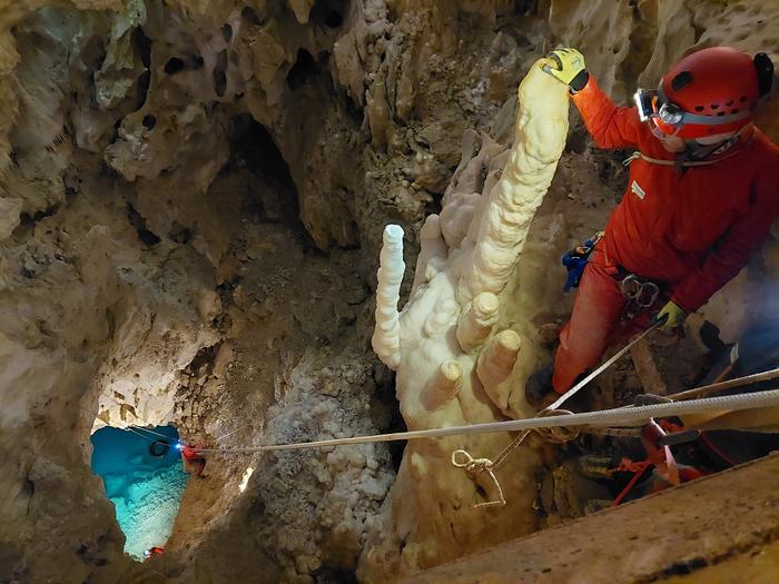 Person peers down 80 foot drop into underground lake