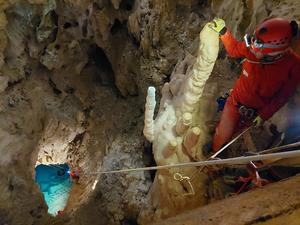 Person peers down 80 foot drop into underground lake