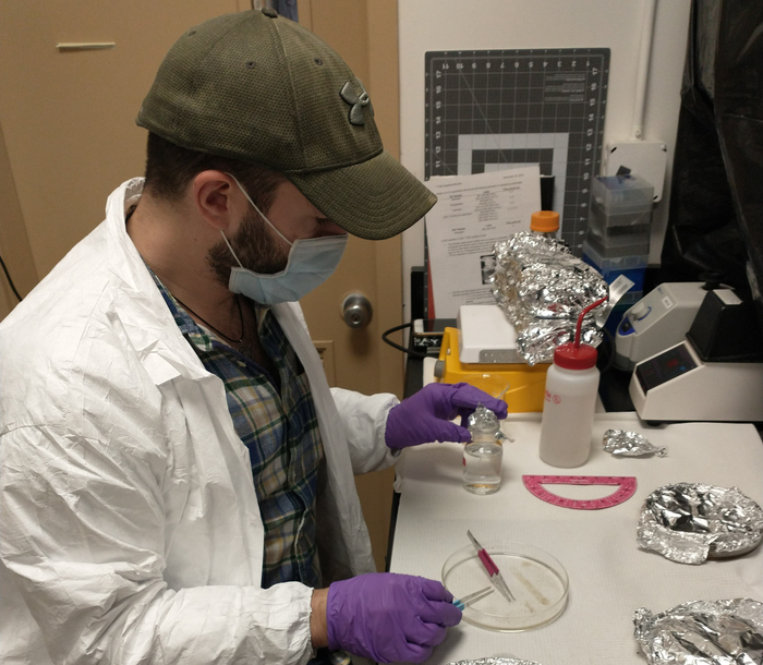 Michael Mazzotta cuts plastic samples to measure respiration signals of microbial communities