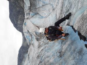 Dr. Edyta Łokas collecting a cryoconite sample from a glacier.