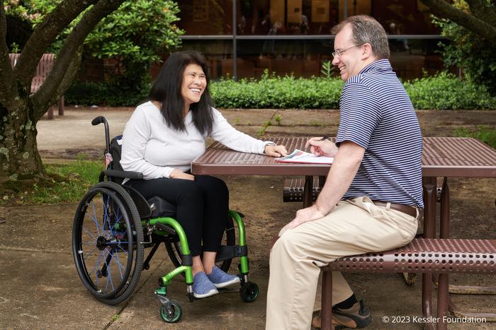 Woman with spinal cord injury seated with caregiver