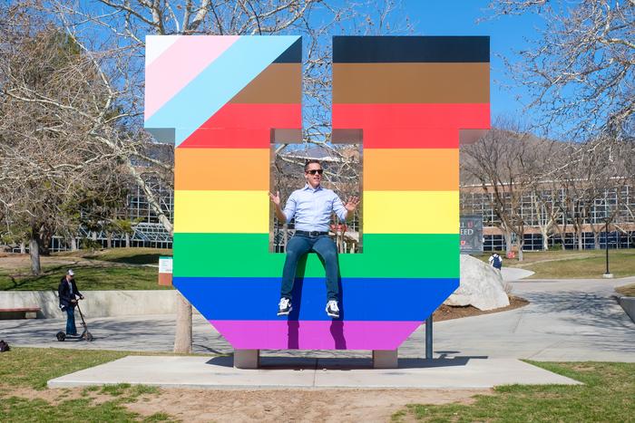 Ramón Barthelemy in front of the "Block U" wrapped for Pride on the University of Utah campus