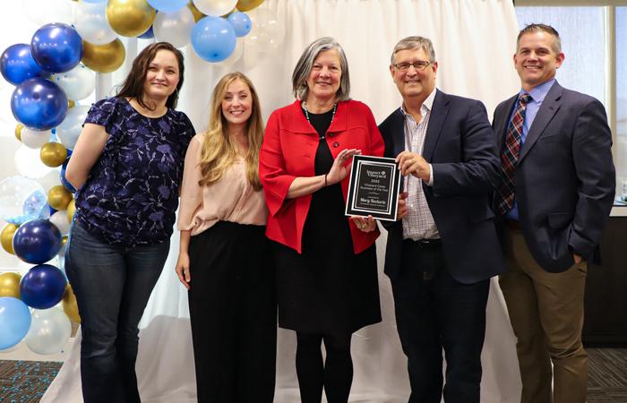 Mary Beckerle and Brad Cairns hold the Vineyard Cares Business of the Year plaque with Mayor Julie Fullmer and others.