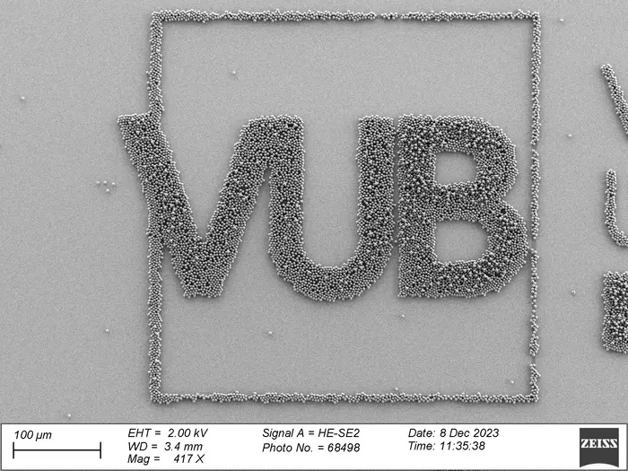 AFM image of microparticles printed in the controlled shape of the VUB logo. The scale is 100µm, the thickness of a human hair.