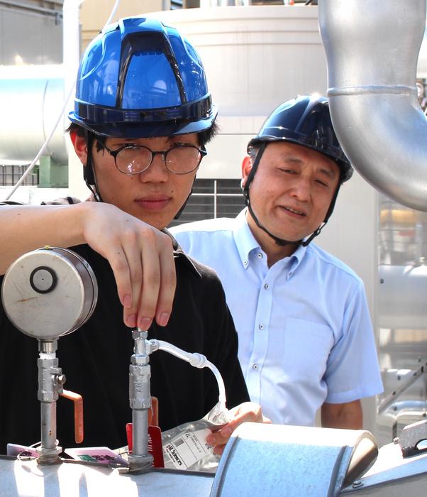 Tsuda (right) and a student working on a demonstration experiment at a sewage treatment plant in Higashinada Ward, Kobe City (provided by TSUDA Akihiko).