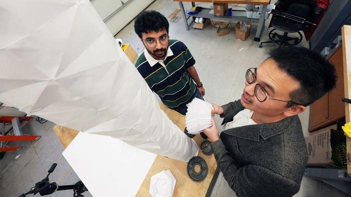 Graduate researcher Vishrut Deshpande and Associate Professor Suyi Li inspect a plant-inspired robot prototype.