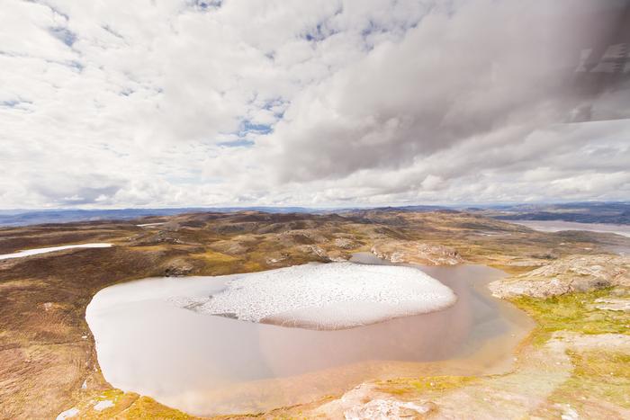 Melting ice on a small Greenland  tundra pond