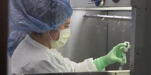 UHS pharmacy technician Katie Sasina draws a syringe in the pharmacy's sterile compounder.