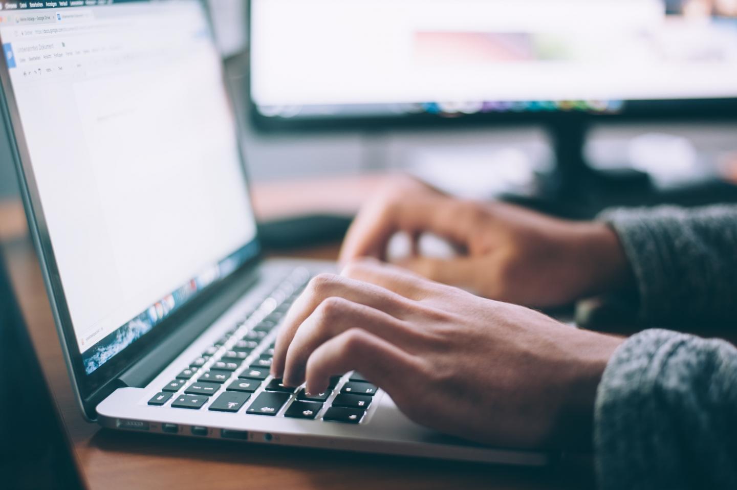 Photo of person typing on a laptop