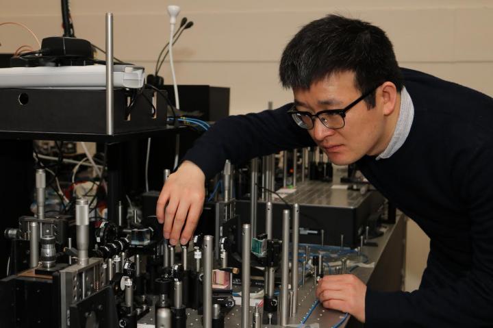 Photograph of Xiaogang Qiang and His Experimental Setup