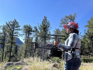 Nayani Ilangakoon carries a drone that was used to study a burn scar in Colorado