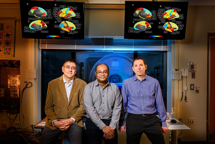 Research team standing in front of an MRI machine.