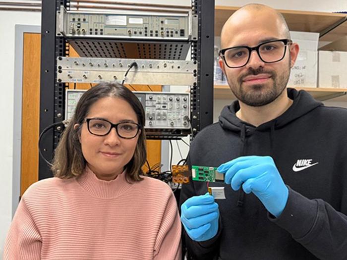 Researchers holding the biosensing platform they developed