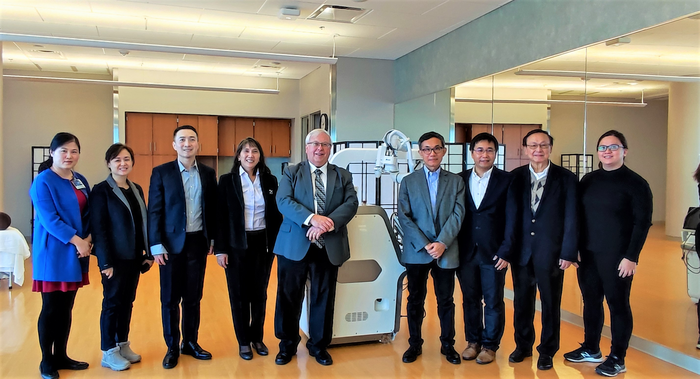Group photo of workshop participants and the AiTreat EMMA massage robot held at the Mayo Clinic