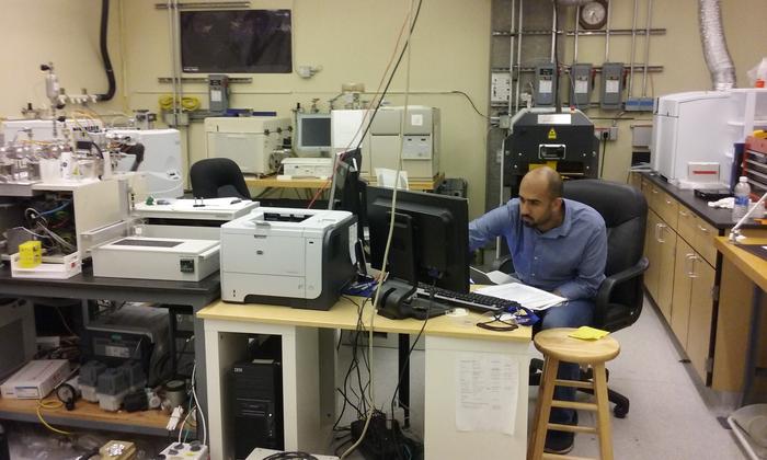 Nasser Al Qattan monitoring the instruments as they run analyses on samples - photo by Gregory Herbert