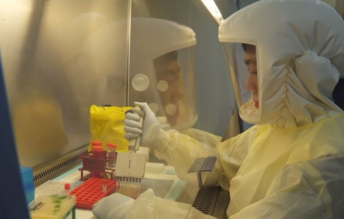 Researcher preparing SARS-CoV-2 samples for testing in BSL-3 Core Facility at NUS Medicine