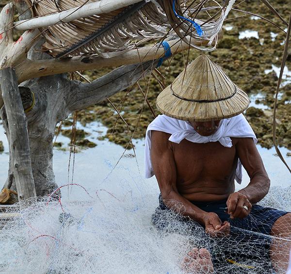 Samal man from Mindanao, Philippines, fixing a fishing net