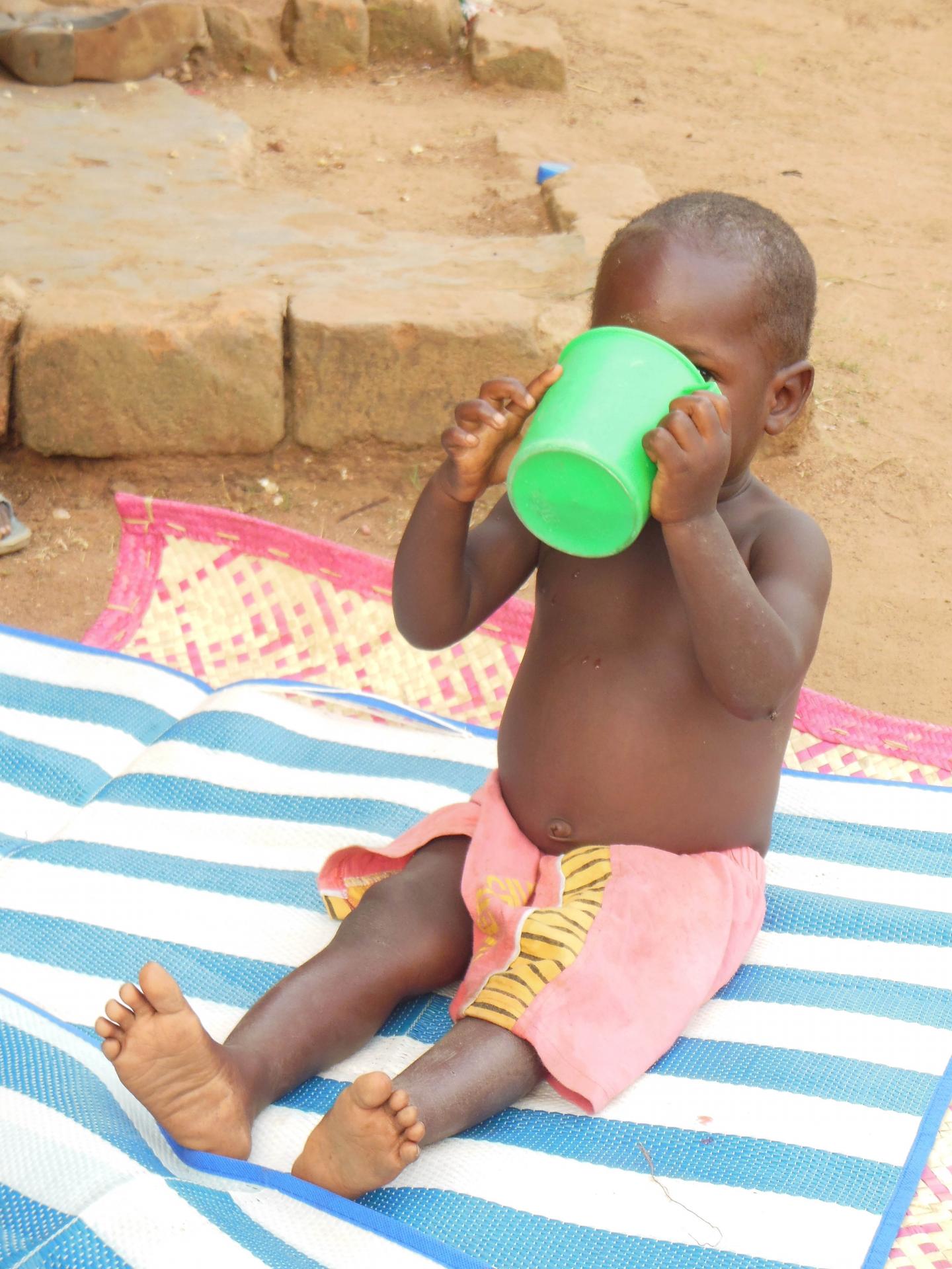 Child drinking from large plastic cup