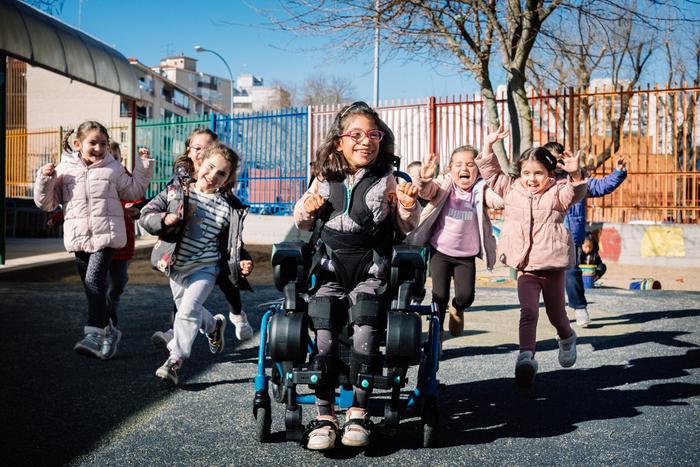 A girl uses the exoskeleton in her schoolyard