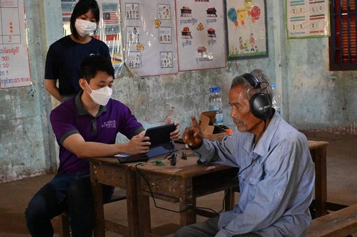 A 71-year-old villager near Poipet, Cambodia, undergoes hearing tests to receive a hearing aid tailored to him.