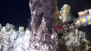 ROV SuBastian takes a geologic sample from a hydrothermal black smoker