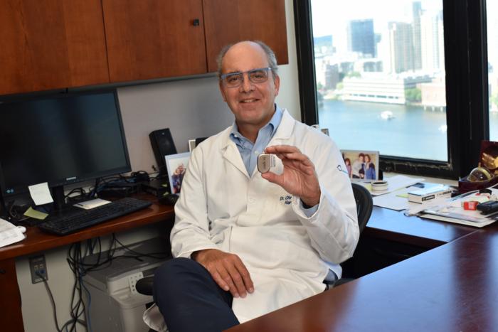 Dr. Christopher Hartnick holding hypoglossal nerve stimulation implant.