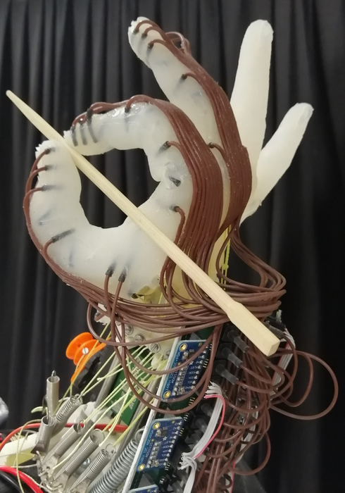 Robot hand holding a wooden chopstick