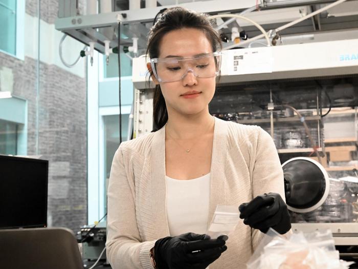 A student holds a battery coin cell