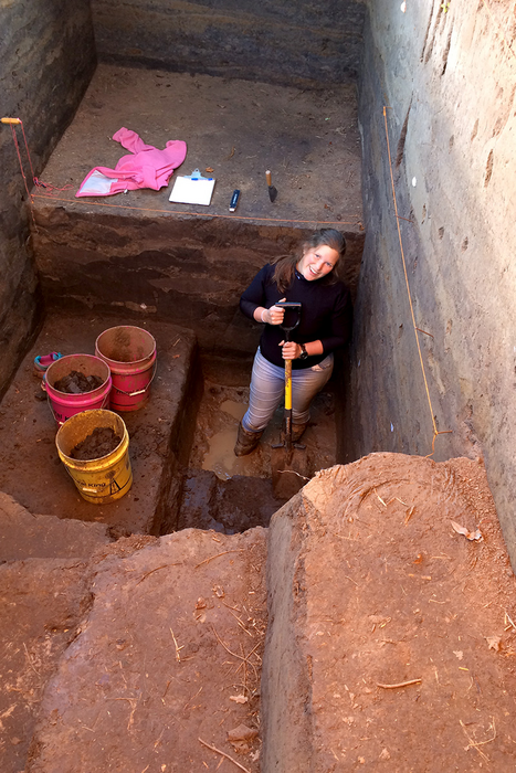 Rankin standing with a shovel in a very deep trench.