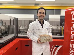 Dr Hugo Olierook with a rock from the Jack Hills in Western Australia, which contained the zircon crystals analysed in this research