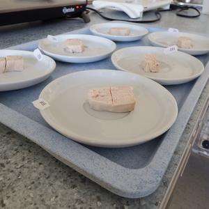 chicken meat sliced and on lines of white saucers on a blue/grey serving tray