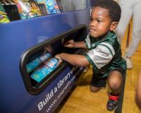 Child Taking a Book Out of the Book Vending Machine