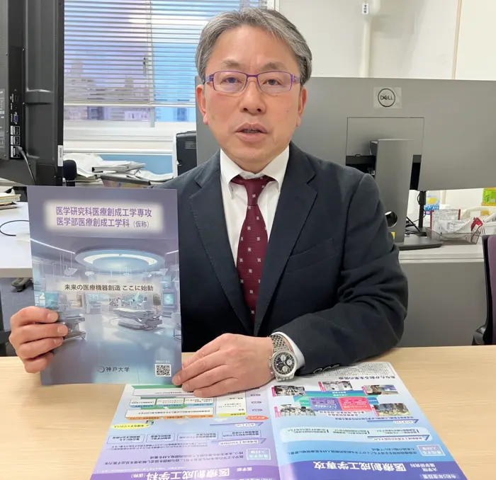 Muragaki holds a brochure of the Department of Medical Innovation Engineering.