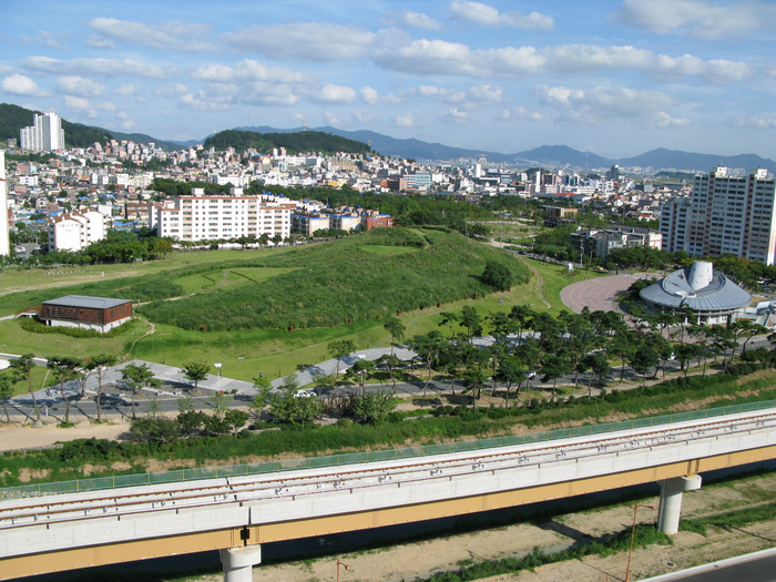 General perspective of Daeseong Dong Tumulti in Gimhae. This funerary complex dates to the Three Kingdoms period of Korea and more than 200 graves have been documented. (© John Bahk)