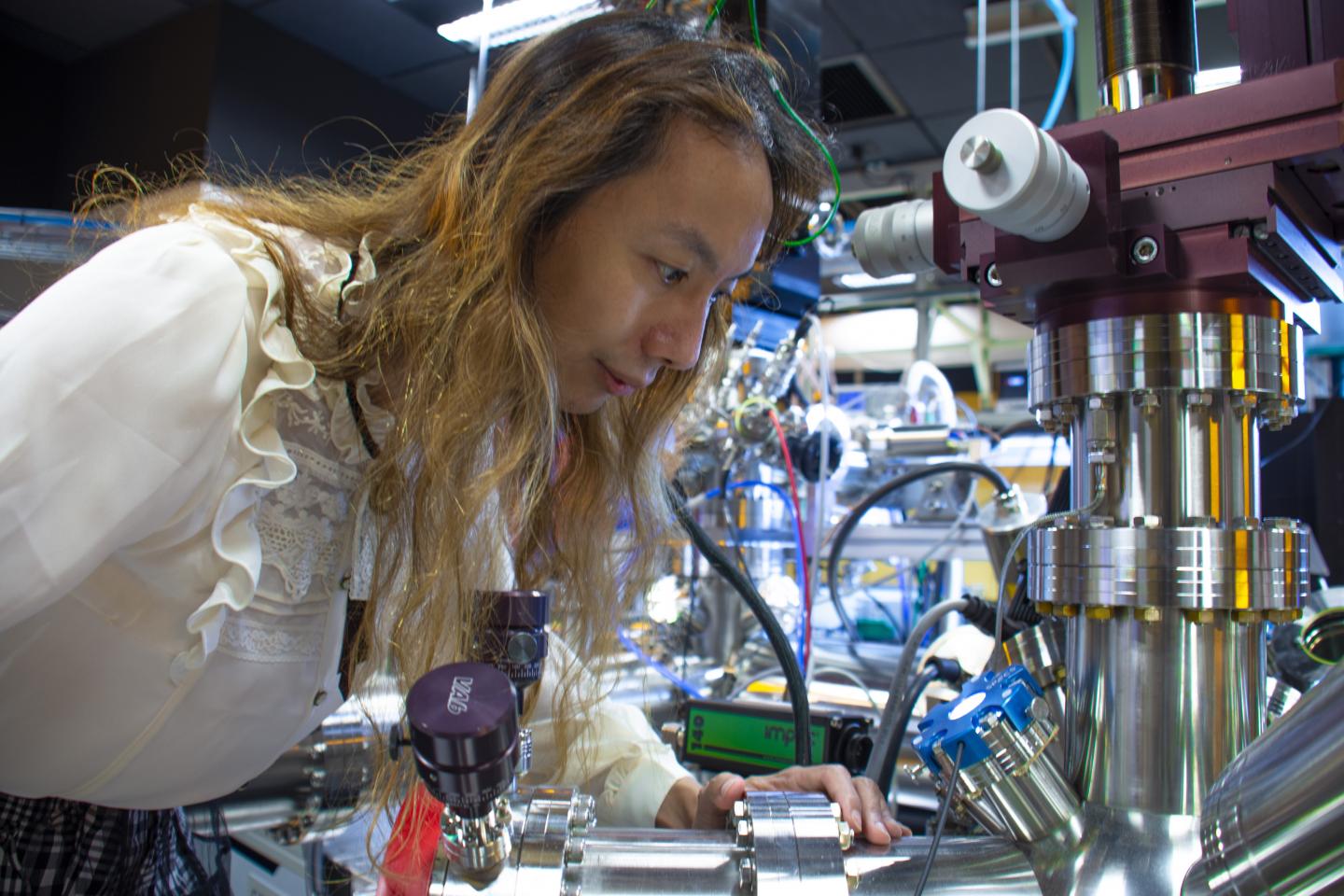 Scientist in the Femtosecond Spectroscopy Unit at OIST Examines Electron Microscope