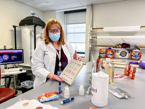 In support of the PGTIDE study, Kristi Niehaus, Tide scientist, Strategic Innovation & Technology at P&G, displays a stain set that will be used to test Tide detergent solutions aboard the International Space Station