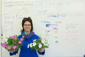 Tamar Friedlander holding two petunias