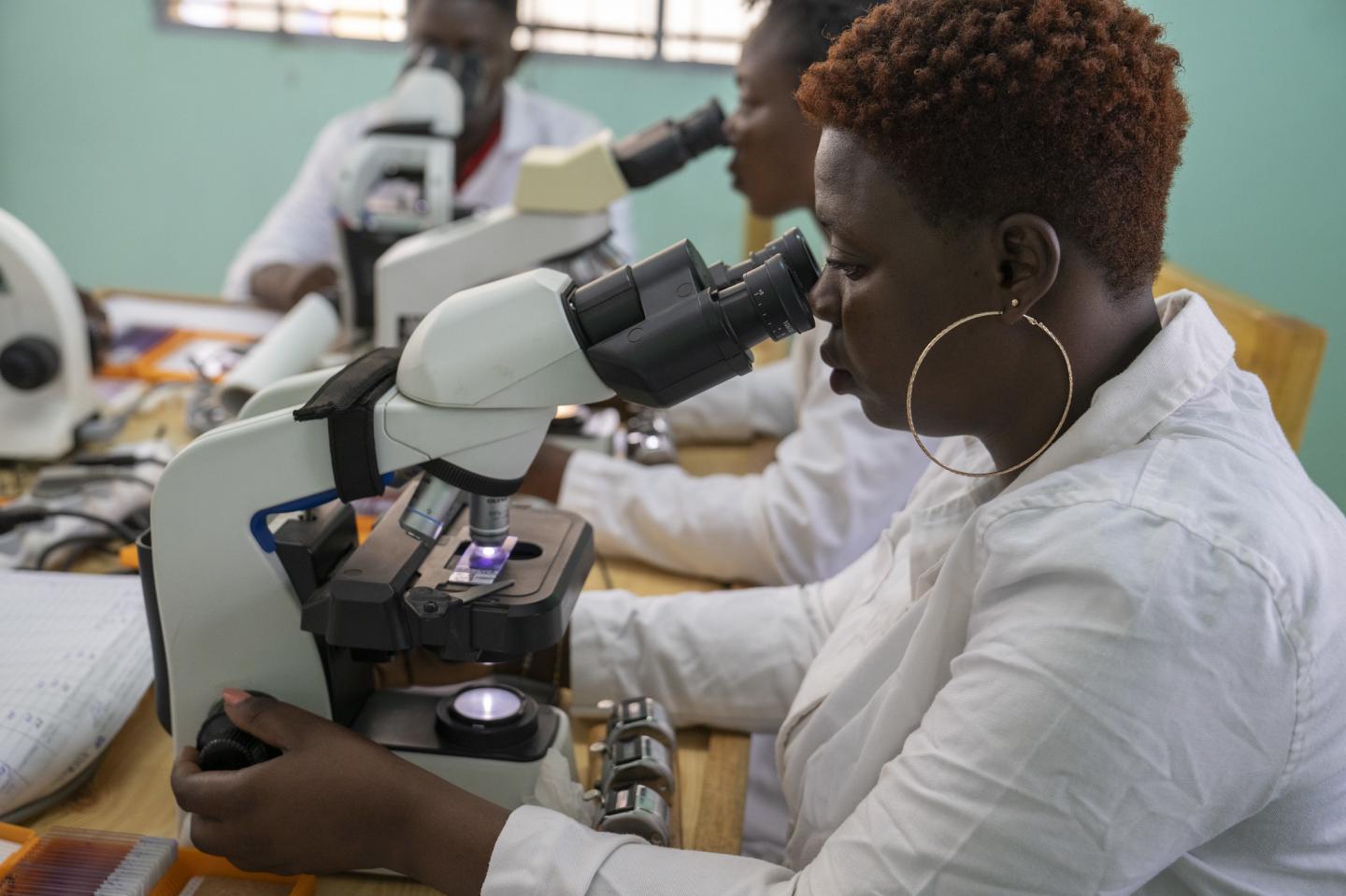 Researcher looks through microscope