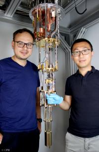 Dmitri Efetov and Xiaobo Lu Holding the Device in Front of the Setup