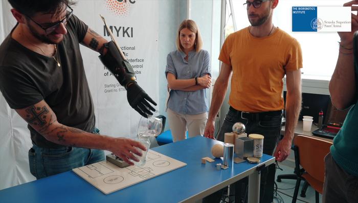 C055800296.png: Experimental tests on robotic prosthesis: patient pours water into a glass