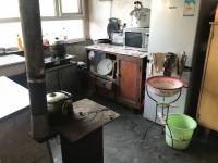 Electric Cooking Equipment Sits Alongside Traditional Stoves in a Kitchen in Rural China