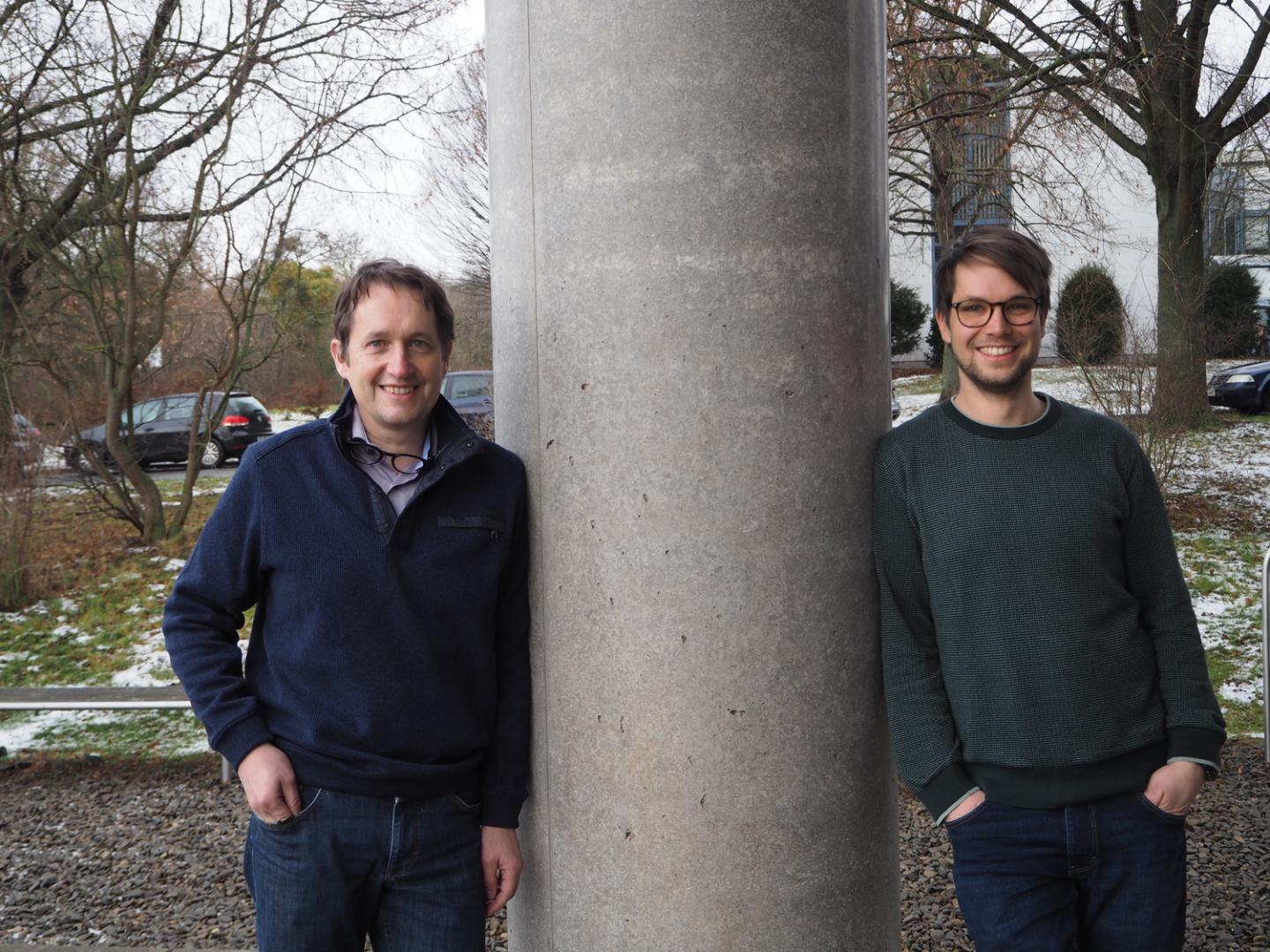 Researchers either side of a large grey column