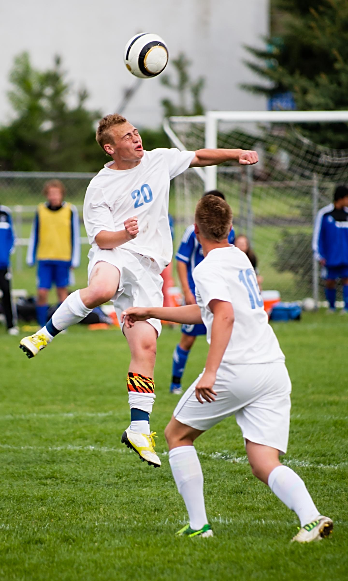 High school soccer player heading a ball during a game