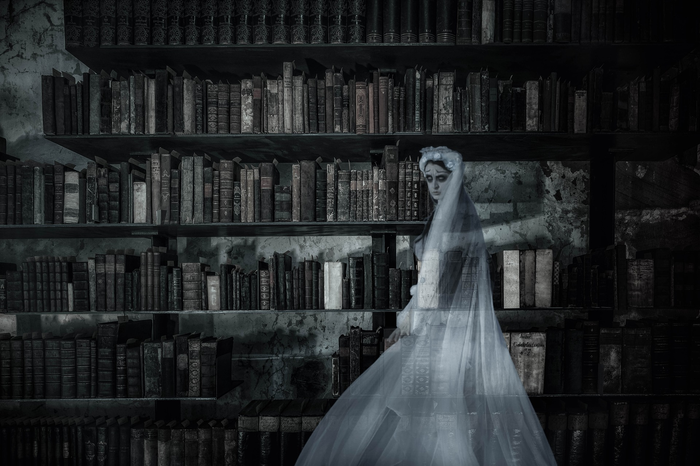 Ghostly figure pictured in front of an old library shelf.