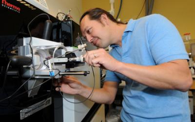 Biogeochemist Mak Saito Using a Machine in Lab