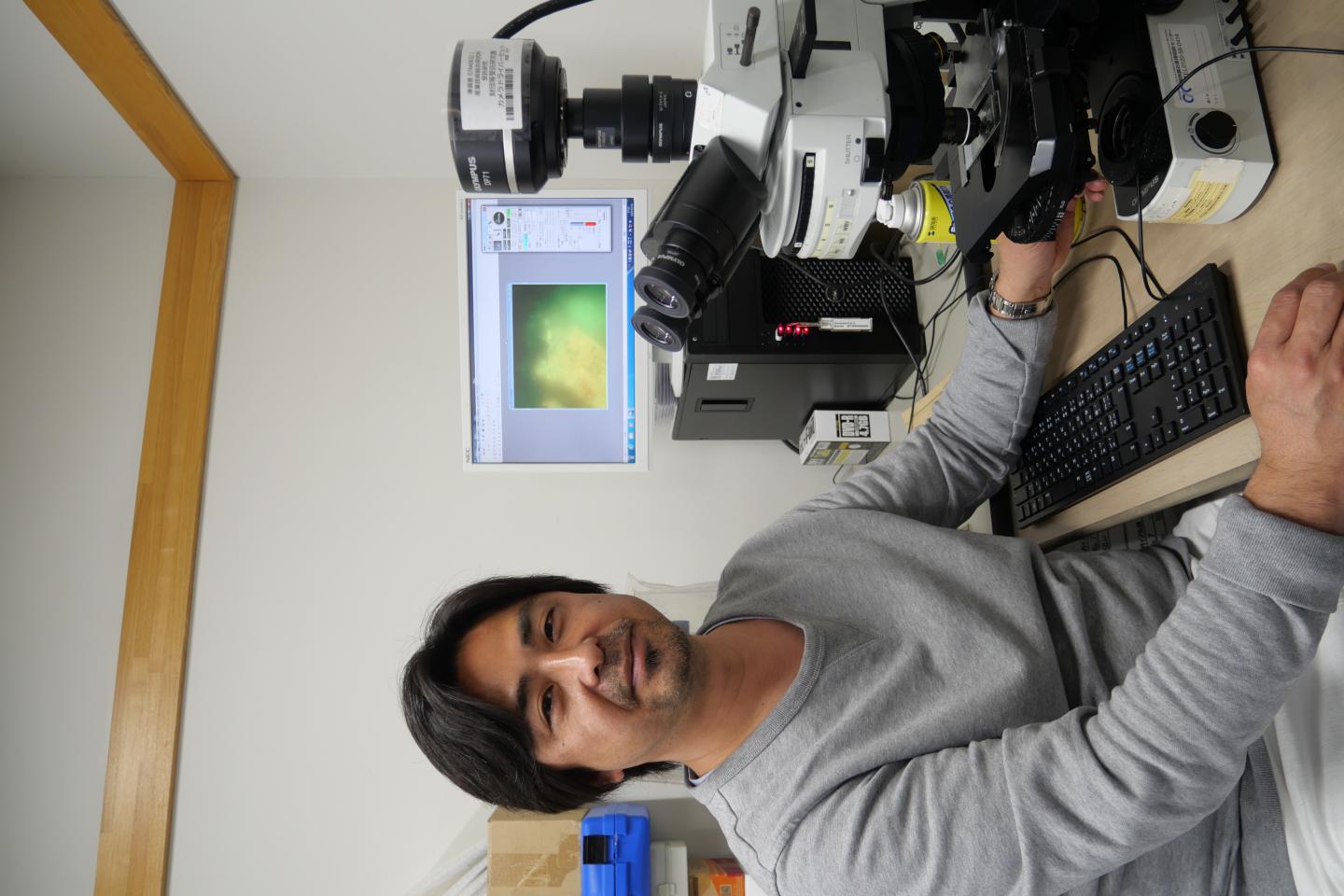 Associate Professor Yohey Suzuki at the Microscope with Rock Sample
