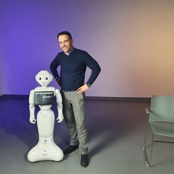 Konrad Maj, PhD, from SWPS University, with a robot taking part in the study