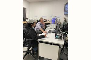 Aaron Celestian (right) analyzing crystals on the scanning electron microscope